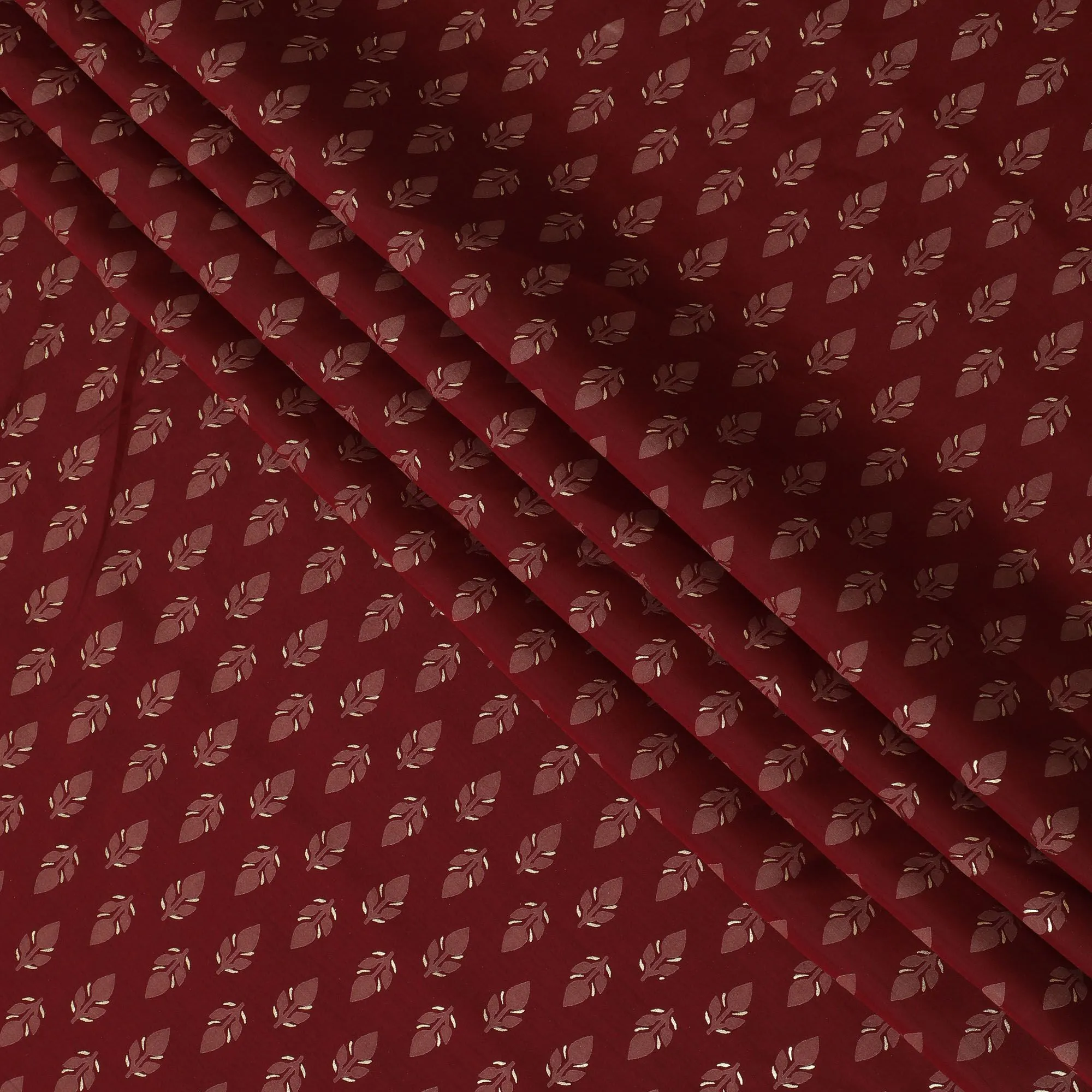 Maroon Synthetic blended cotton fabric with brick red and gold foil print in floral design-D16738